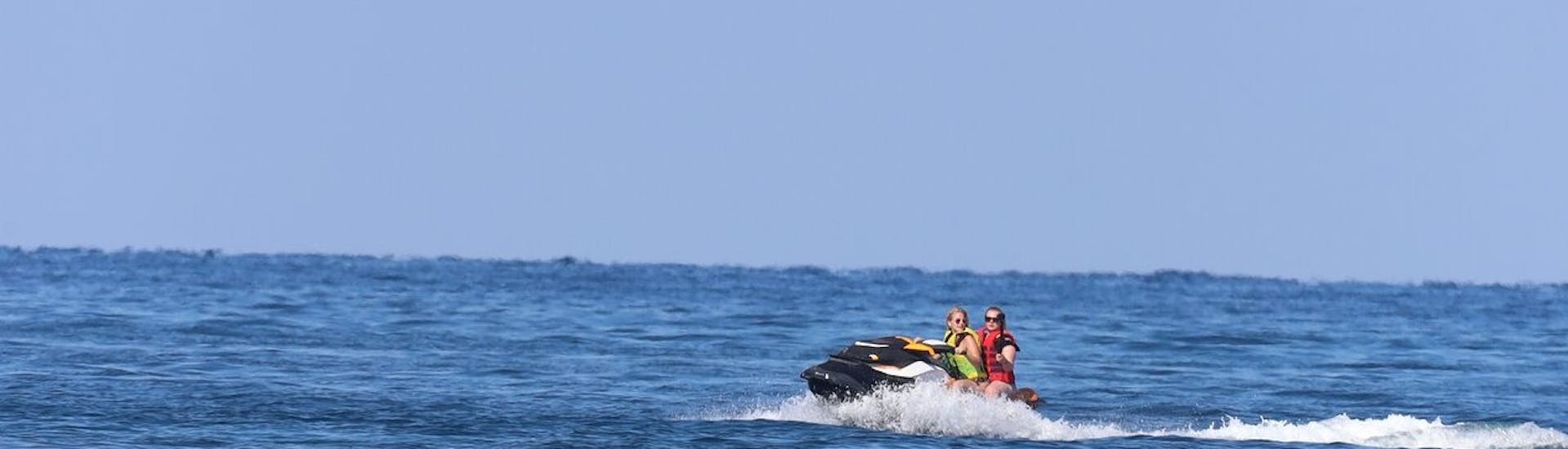 Dos chicas montando en una moto acuática en la playa de Banana en Vasilikos con Banana Watersports.