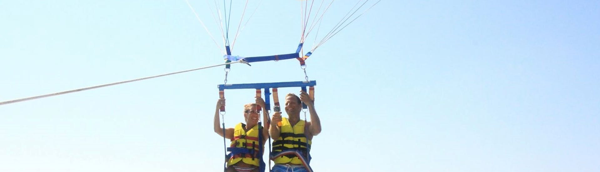 Una coppia pratica il parasailing a Banana Beach - Vasilikos con Banana Watersports.