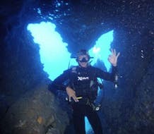 Un participante está bajo el agua mostrando una señal con la mano en el "PADI Discover Scuba Diving" en Zakynthos con Diver's Paradise.