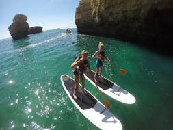 Zwei Frauen stehen auf einem SUP während des Stand-Up-Paddleboarding von Galé Beach entlang der Algarveküste mit Nautifun Galé Albufeira.