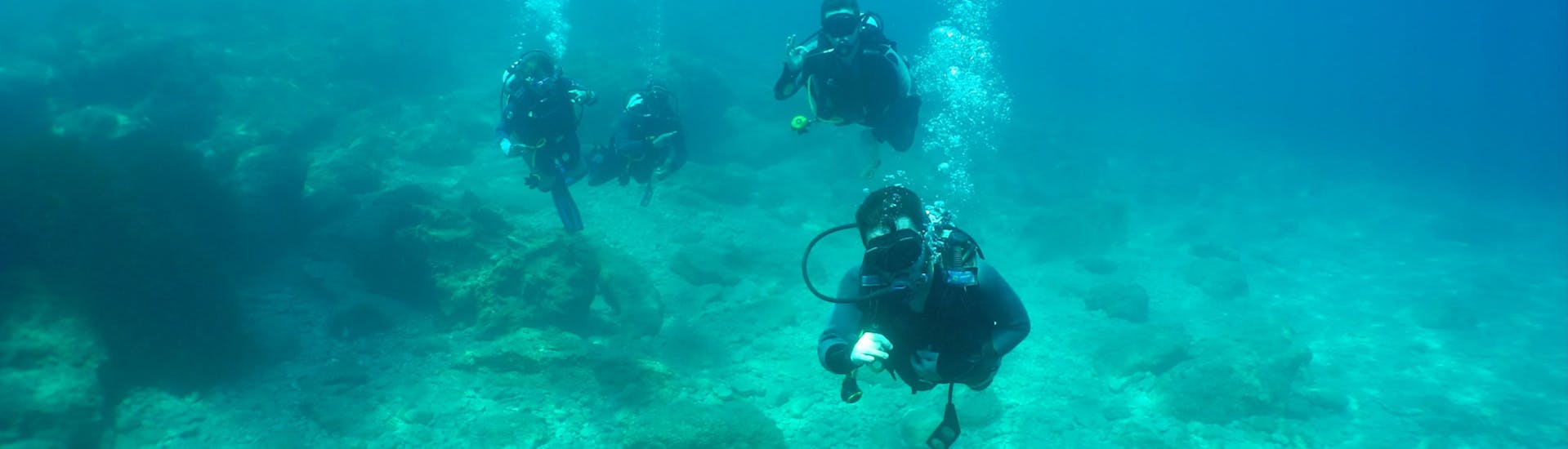 Participantes en una inmersión guiada bajo el agua sobre un arrecife, con Diver's Paradise en Zakynthos.