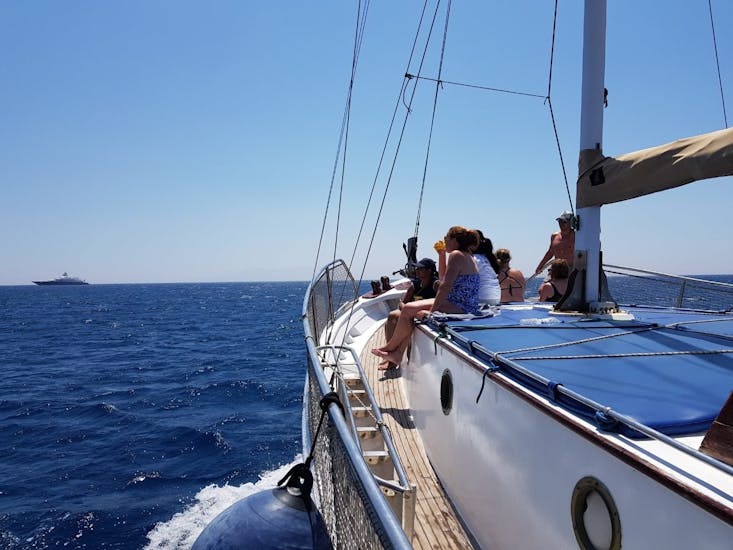Des gens sont sur notre bateau traditionnel en bois lors de la Balade en bateau à Delos et Rhenia depuis Mykonos avec Mykonos Cruises.