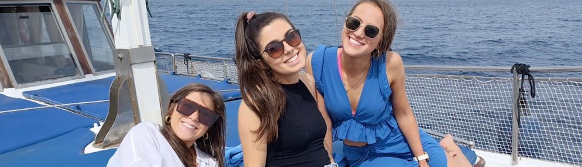Trois filles profitent de leur temps sur le bateau pendant la balade en bateau le long de la côte sud de Mykonos jusqu'à Delos avec Mykonos Cruises.