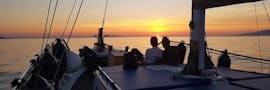 Deux personnes sur le bateau de Mykonos Cruises profitant de la balade en bateau au coucher du soleil autour de Mykonos.