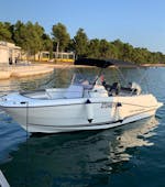 Le bateau à moteur au port au coucher du soleil disponible à la location de bateaux à Pula et Medulin avec Zoom Boats Istria.