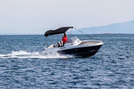 Un uomo a bordo di un motoscafo durante il Noleggio barche a Medolino (fino a 6 persone) con Zoom Boats Istria.