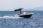 Ein Mann auf dem Motorboot fährt auf dem Meer das man im Bootsverleih in Medulin mit Zoom Boats Istria ausleihen kann.