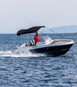 Ein Mann auf dem Motorboot fährt auf dem Meer das man im Bootsverleih in Medulin mit Zoom Boats Istria ausleihen kann.