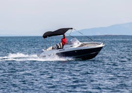 Un hombre navega en el mar en una lancha que se puede alquilar, en el alquiler de barcos en Medulin con Zoom Boats Istria.