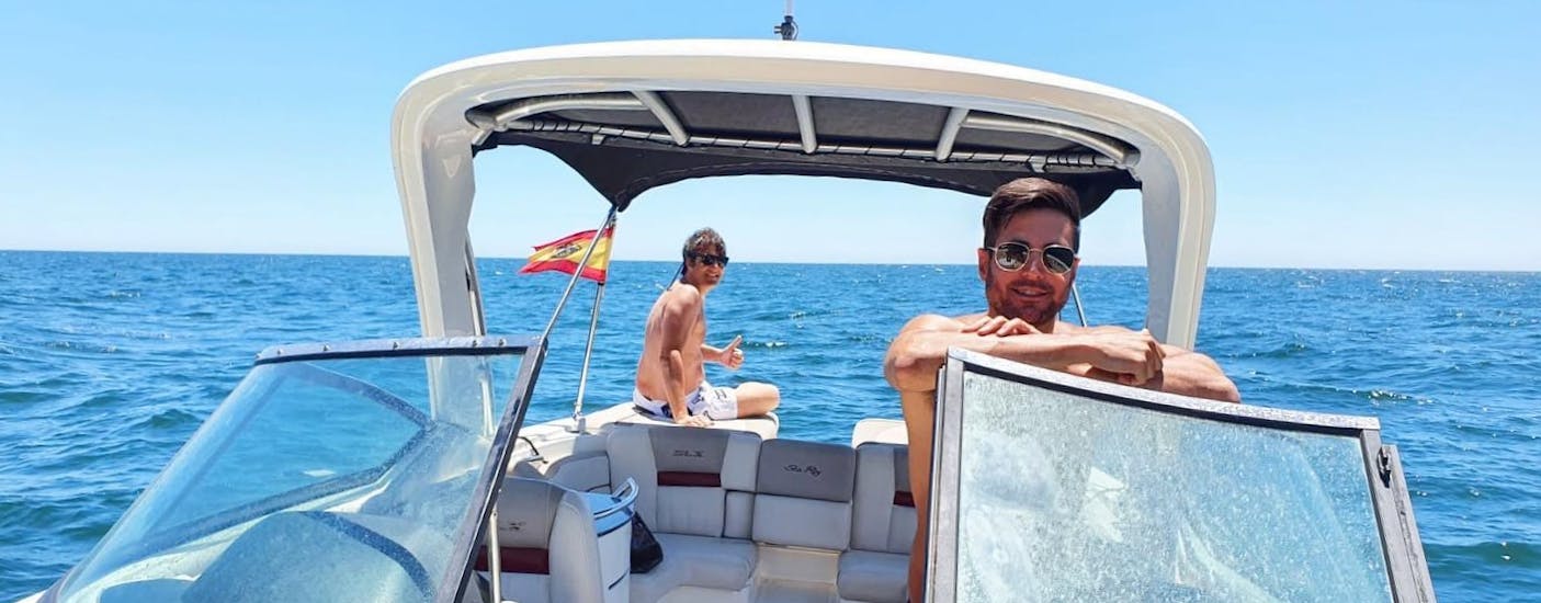 Dos amigos sonriendo mientras navegan en un barco de lujo durante un alquiler de barcos en Marbella con Marbella Renting Boat.