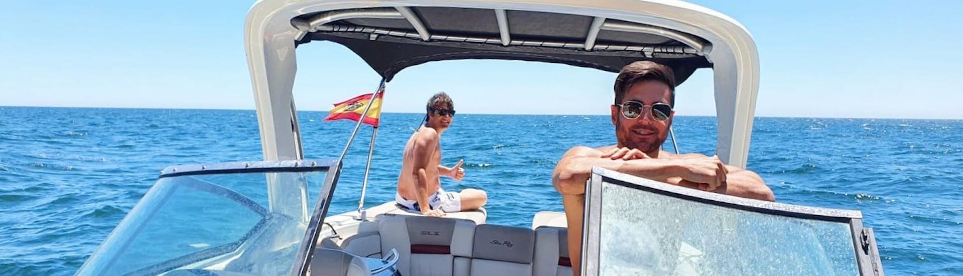 Due amici sorridono mentre navigano su un'imbarcazione di lusso durante un noleggio barca a Marbella (fino a 12 persone) con patente nautica con Marbella Renting Boat.