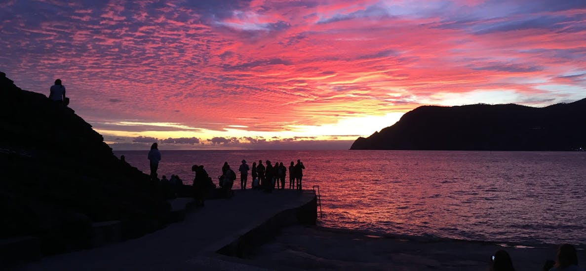 Eine Gruppe von Menschen bewundert das Meer bei Sonnenuntergang während der Bootstour nach Porto Venere und den Inseln mit Schnorcheln.