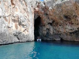 Vista di una barca che entra in una grotta durante il giro in barca alle grotte dell'Adriatico da Santa Maria Leuca con Leuca Due Mari.