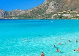 Gente disfrutando del agua en la playa de Falasarna durante su viaje privado en barco a la laguna de Balos y la playa de Falasarna, con Chania Balos Cruises.