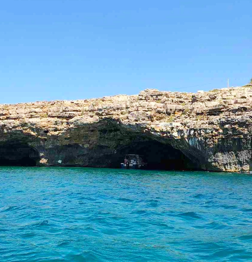 Blick auf ein Boot in einer Höhle während unserer Bootstour zu den Höhlen von Santa Maria di Leuca mit Schnorcheln.