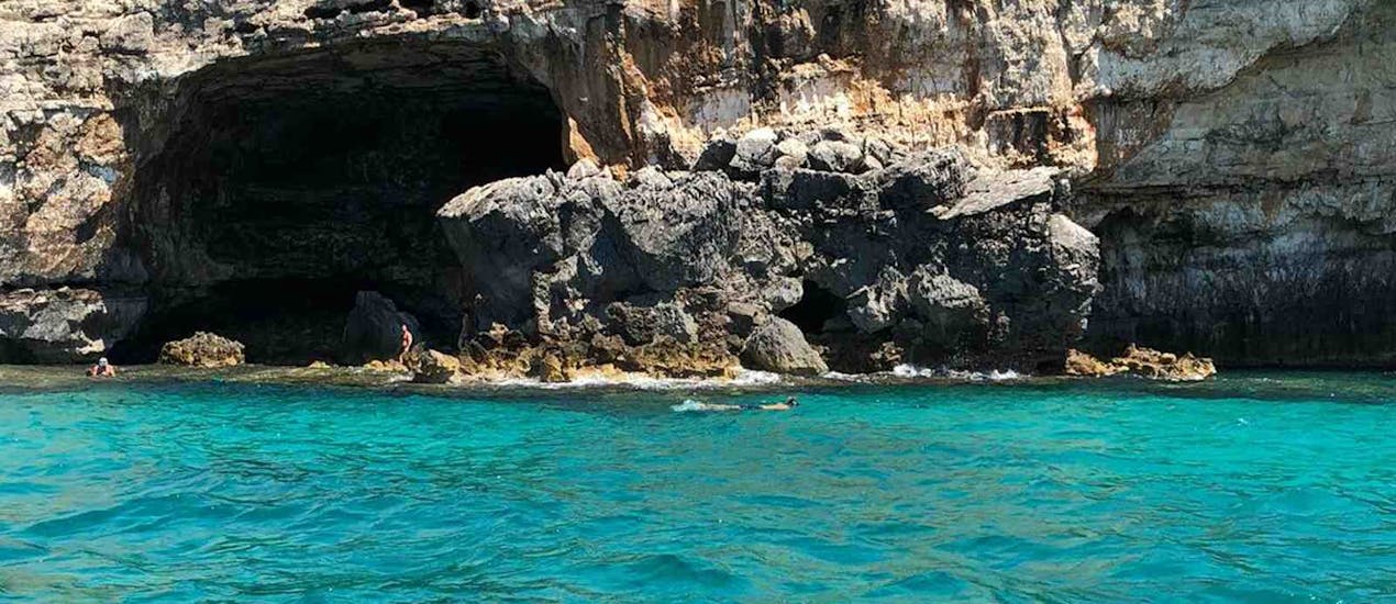 View of a snorkeler in front off a cave during the boat Trip to the Ionic Caves from Santa Maria di Leuca with Leuca due Mari.