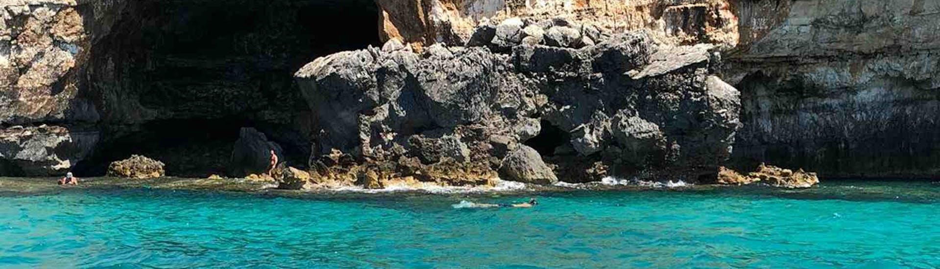 View of a snorkeler in front off a cave during the boat Trip to the Ionic Caves from Santa Maria di Leuca with Leuca due Mari.