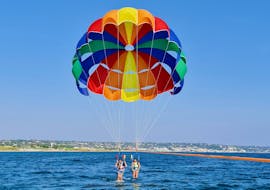Una coppia si sta preparando a volare a un'altezza di 60 metri con un parasailing a Torre Vado con Rosa dei Venti Escursioni.