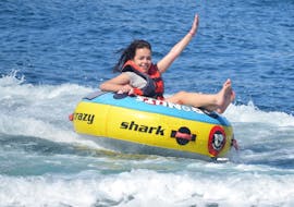 A girl having fun during a Banana Boat Ride and More Towable Tubes in Vilamoura Marina with Vilamoura Watersports Centre.