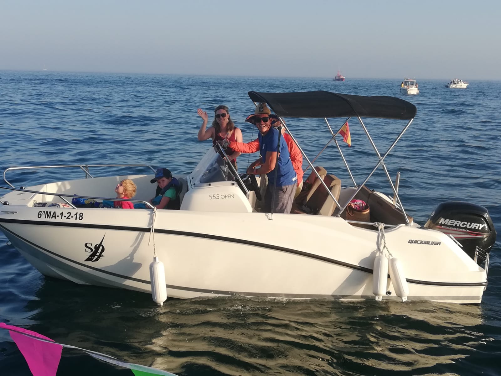 A group of participants on the quicksilver 555 speedboat, surrounded by the beautiful blue waters of the bay of Estepona, during a private boat trip with South Olé Sails Estepona.
