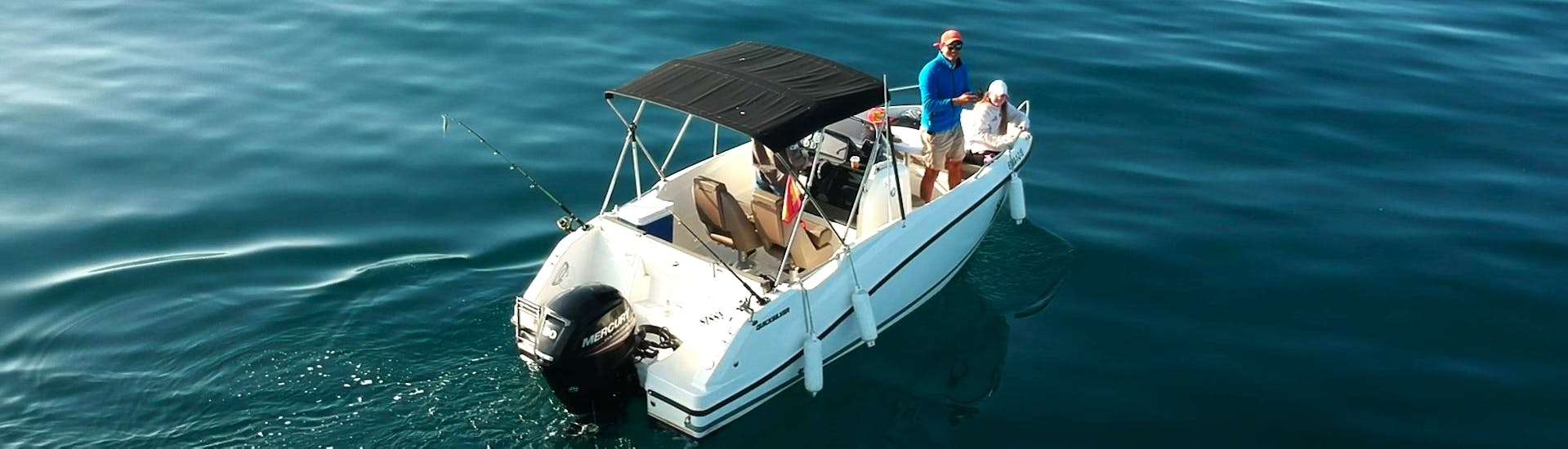 Eine Gruppe von Teilnehmern auf dem Schnellboot Quicksilver 555, umgeben von dem wunderschönen blauen Wasser der Bucht von Estepona, während einer privaten Bootstour mit South Olé Sails Estepona.