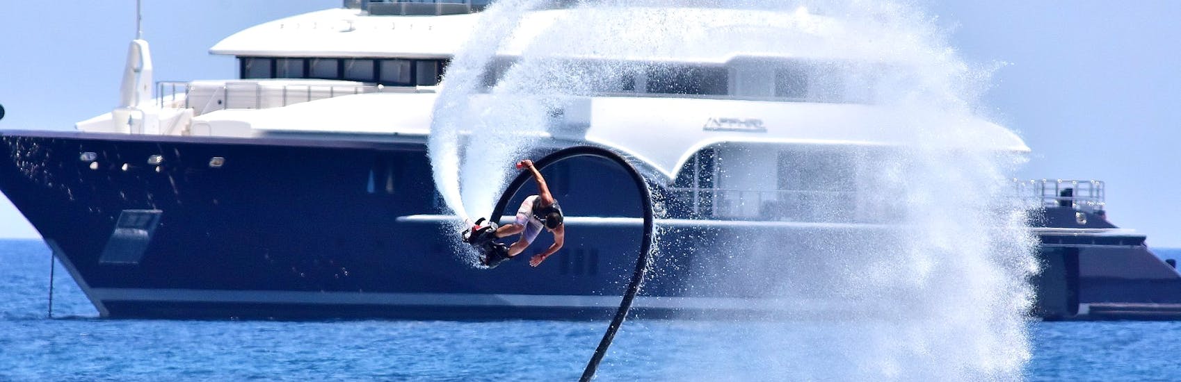 Un uomo fa un'acrobazia sul flyboard noleggiato da St. Nicholas Beach Watersports Zakynthos.