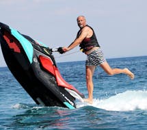 Man does a stunt on a jet ski rented from St. Nicholas Beach Watersports.