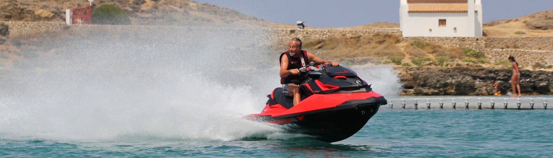 Man rides towards the camera laughing on a jet ski rented from St. Nicholas Beach Watersports.