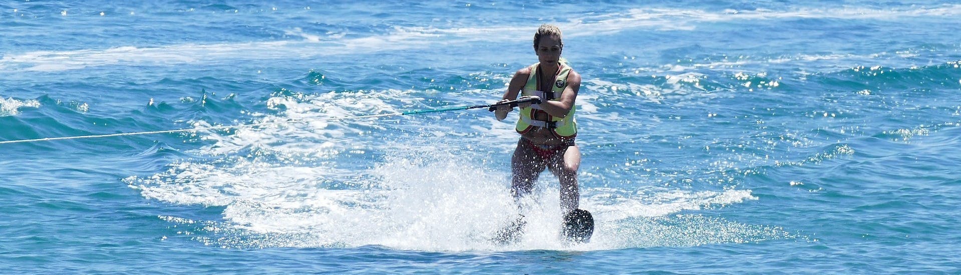Woman stands on a water ski rented from St. Nicholas Beach Watersports.