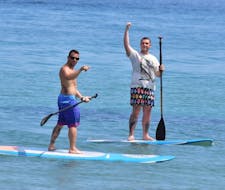 Dos chicos en SUPs alquilados en St. Nicholas Beach Watersports Zakynthos.
