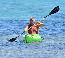 Een man peddelt op een kano gehuurd van St. Nicholas Beach Watersports.
