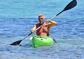 A man paddeling on a canoe rented from St. Nicholas Beach Watersports.
