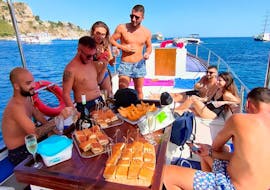 Mensen die eten en drinken tijdens de boottocht vanuit Taormina met wijnproeverij met Boat Experience Taormina.