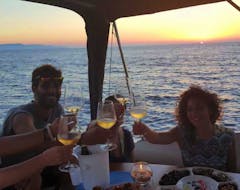 Foto von unseren Kunden, die bei einer Bootstour ab Favignana mit einem Aperitif bei Sonnenuntergang mit In barca con Salvo anstoßen.
