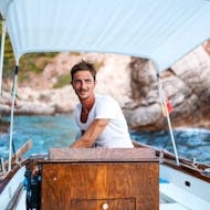 Le skipper de Boat Experience Taormina aux commandes du bateau pendant la balade privée en bateau le long de la côte de Taormina avec snorkeling.
