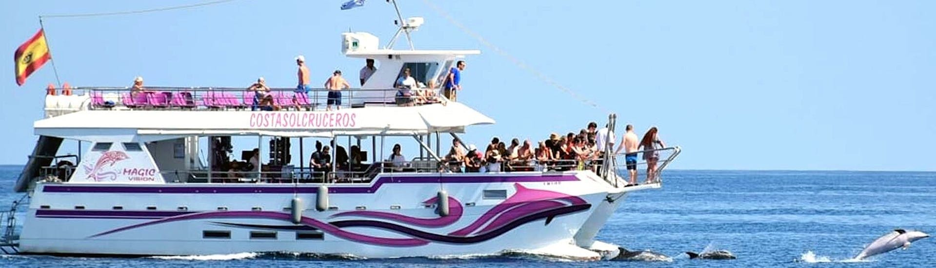 Der Katamaran Magic Vision fährt in der Bucht von Benalmadena mit Teilnehmern, die sich an Bord amüsieren, während einer Katamaranfahrt in Benalmádena mit Delphinbeobachtung mit Costasol Cruceros.
