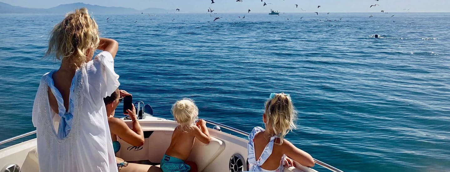 A family looking at the horizon on the boat rental in Estepona with OfBlue.