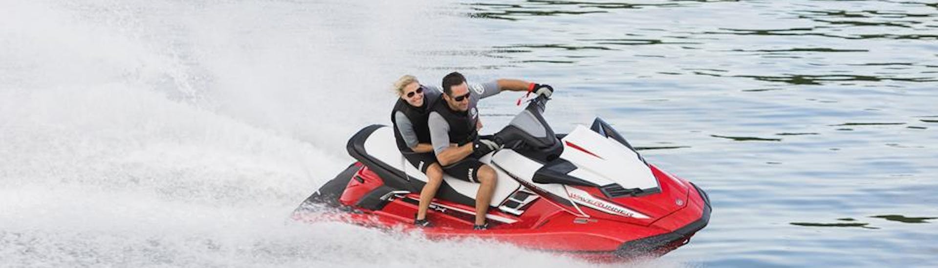 Una pareja chapoteando y divirtiéndose en una actividad de safari en moto de agua en la bahía de Marbella hasta el Puerto de Sotogrande con Marbella Jet Center.