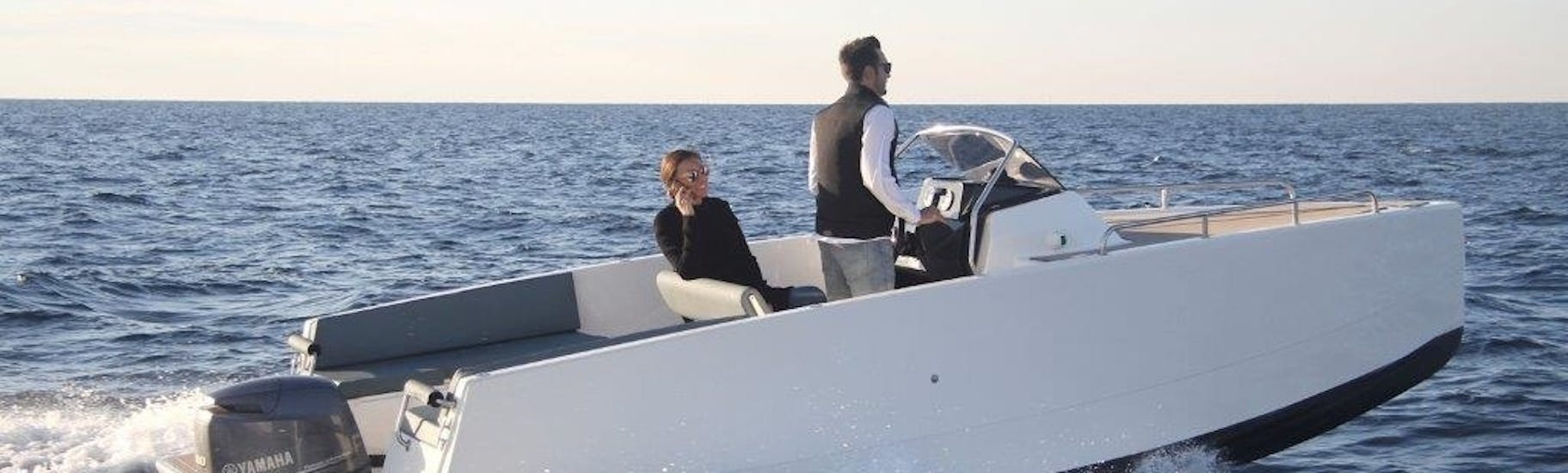 A couple navigating during a Boat Rental in Marbella (up to 7 people) with Royal Catamaran.