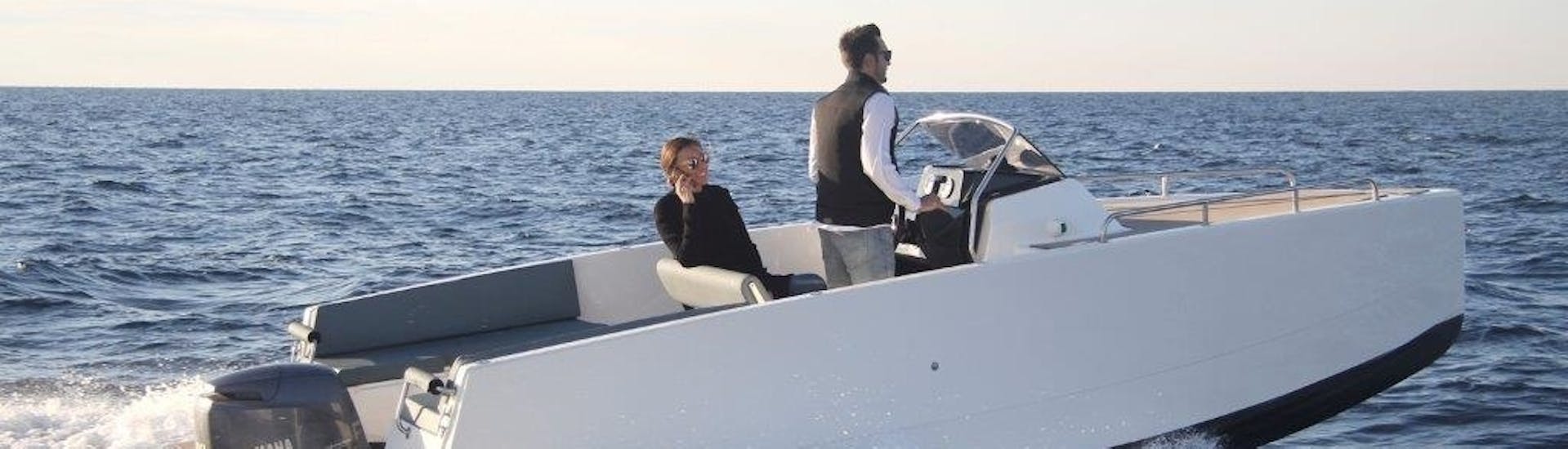 A couple navigating during a Boat Rental in Marbella (up to 7 people) with Royal Catamaran.