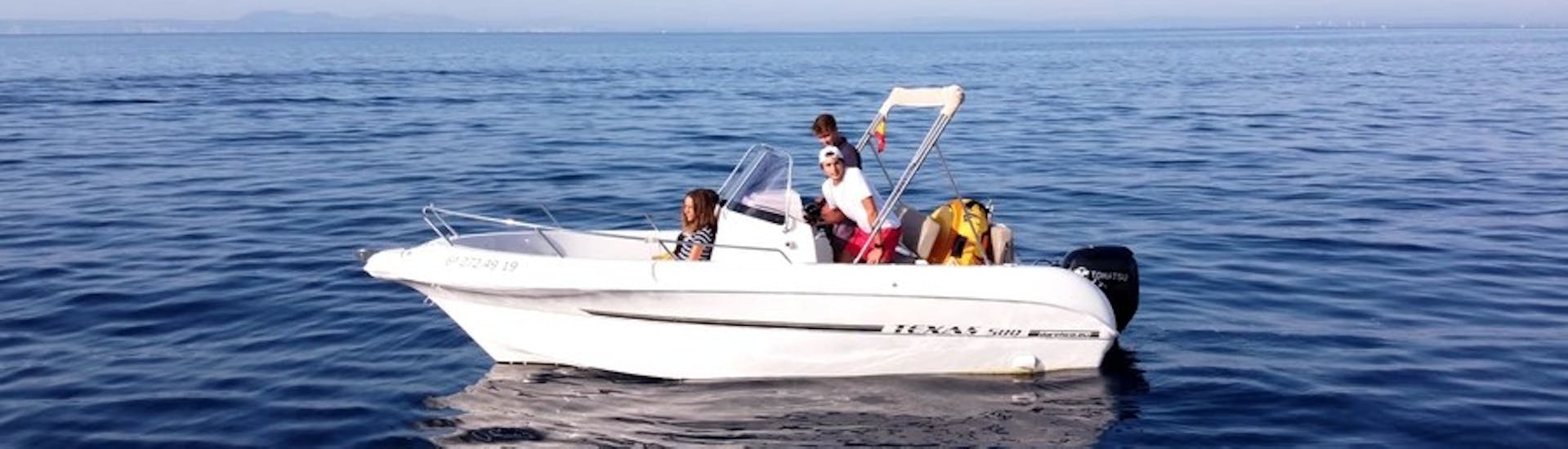 Il moderno motoscafo TEXAS 580 con un gruppo di partecipanti che si divertono navigando sulle acque turchesi della baia delle rose durante il noleggio barca in Costa Brava per un massimo di 6 persone con patente con Maxi Boats Costa Brava.