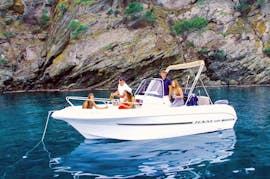 La elegante lancha a motor TEXAS 580 de pie sobre las aguas turquesas de la bahía de roses con un grupo de amigos a bordo duante un alquiler de barco en la Costa Brava para hasta 6 personas con licencia con Maxi Boats.