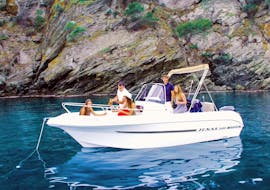 The stylish TEXAS 580 motorboat standing on the turquoise waters of the bay of roses with a group of friends aboard during a boat rental in Costa Brava for up to 6 people with licence with Maxi Boats.