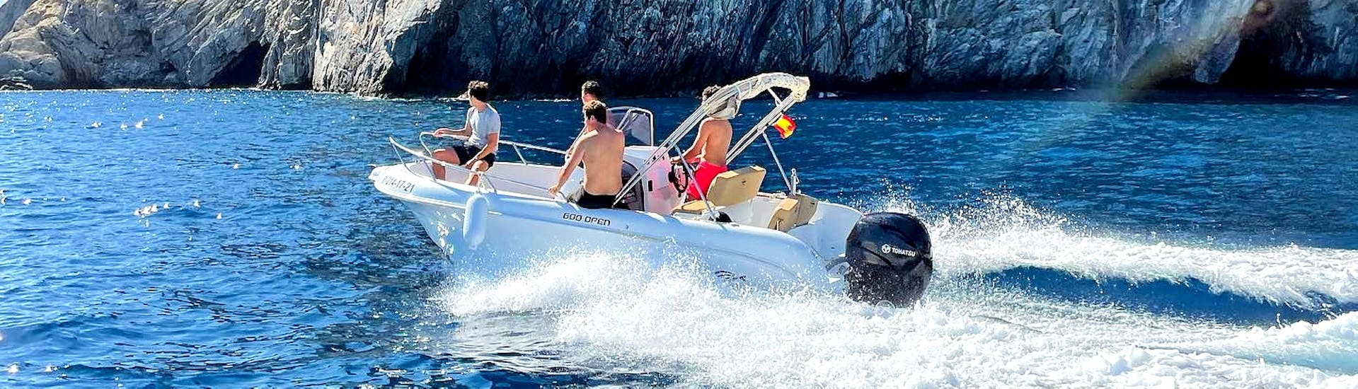 A couple having fun on the ASTEC FIBER 450 motorboat surrounded by turquoise waters of the Bay of Roses during a boat rental for up to 5 people with Maxi Boats license.