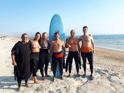 Eine Gruppe von Leuten lächelt nach ihrer Surfstunde in der Nähe von Lissabon in Costa da Caparica mit der GetWet Surf School.