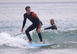 Ein Mann surft während einer privaten Surfstunde in der Nähe von Lissabon in Costa da Caparica mit der GetWet Surf School.