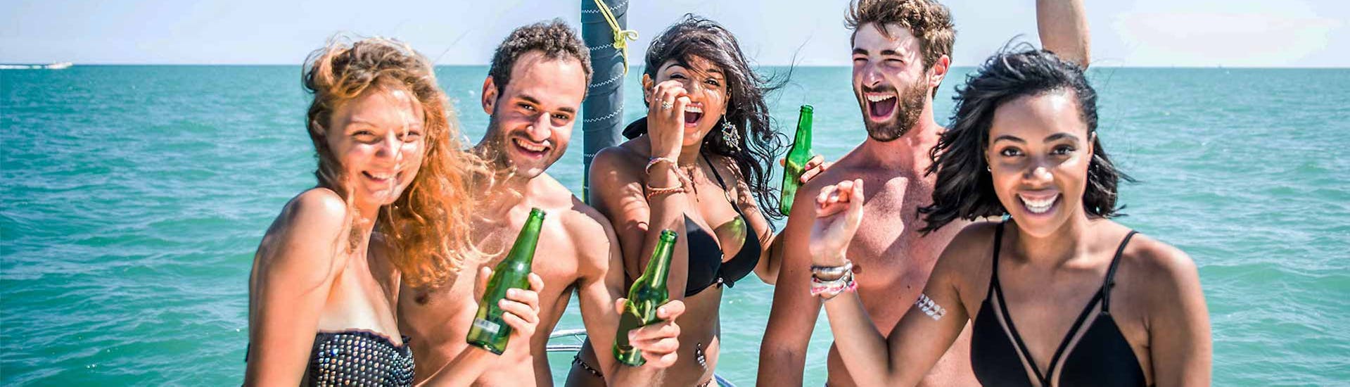 Een groep deelnemers drinkt en amuseert zich op een partyboot in Mykonos tijdens een activiteit met de Mykonos Boat Club.