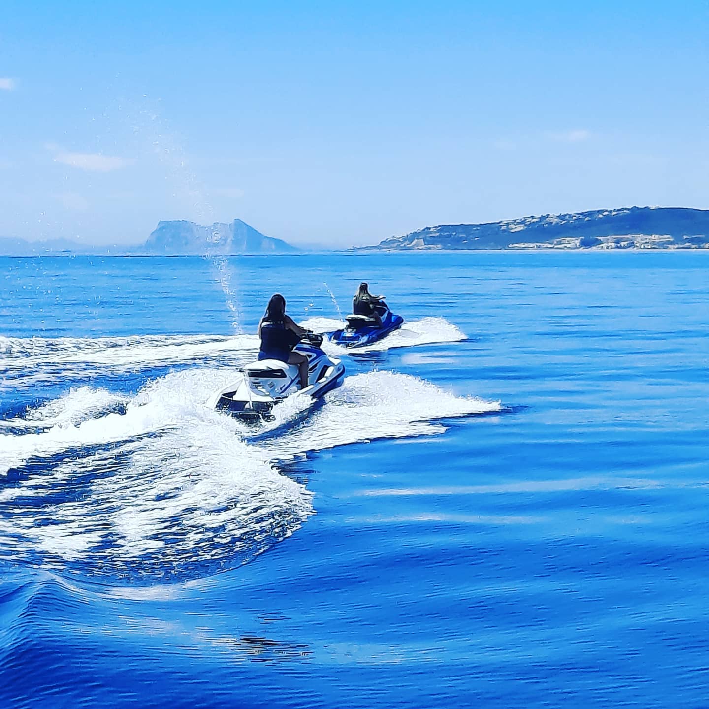 Dos amigos en moto de agua recorriendo la bahía de Estepona, contemplando el paisaje durante un alquiler de moto de agua con South Olé Sails.