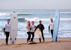 A group of people with their surfboards during a surf lesson in Ericeira on Praia de Ribeira d'Ilhas with Ericeira Waves Surf School.