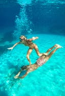 Two people under water during the Boat Trip around the Šibenik Archipelago with Swimming with Anima Natura Šibenik.